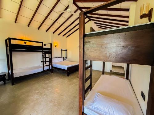 a room with two bunk beds in a room at Go Yala Farm Villa in Tissamaharama