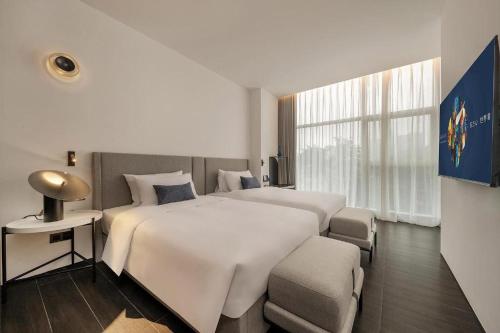 a hotel room with two beds and a window at eLong Hotel (HUA Shenzhen Bay Branch) in Shenzhen