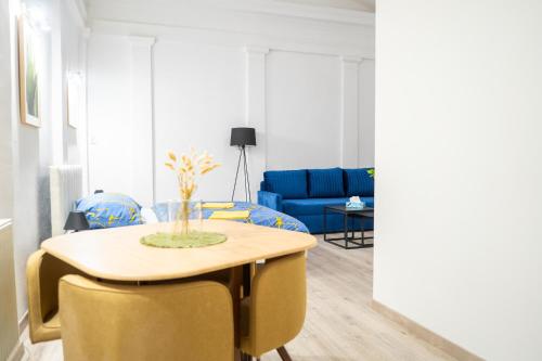 a living room with a table and a blue couch at Cozy Main Square Apartment III with Breakfast in Košice