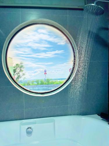 a round window in a bathroom with a shower at Sunset Homestay Villa Tam Đảo in Tam Ðảo