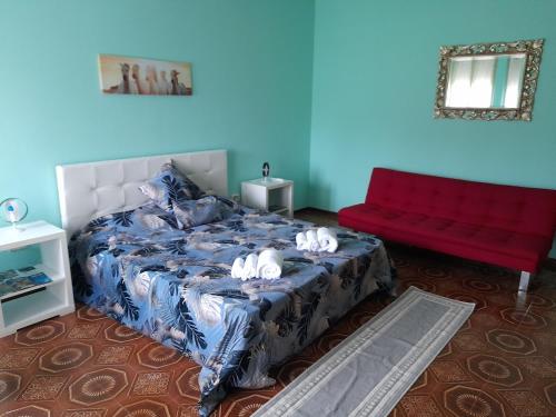a bedroom with a bed and a red couch at Appartment Lago e Natura in Sandra