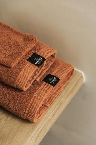 two towels sitting on top of a wooden shelf at Hoeve De Hemel in Zuienkerke