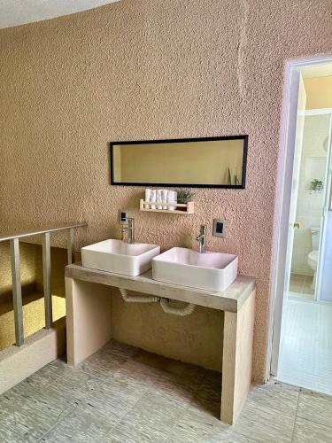 a bathroom with two sinks and a mirror at Casa Artemisa hostal in Guadalajara