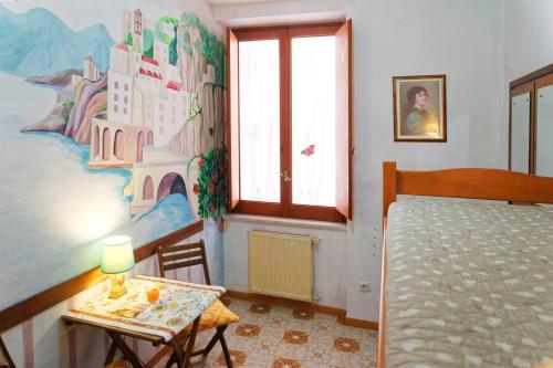 a bedroom with a bed and a table and a window at CristallPont Amalfi Day in Atrani