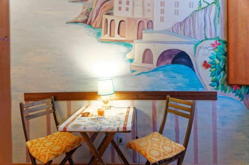 a table and two chairs in front of a mural at CristallPont Amalfi Day in Atrani