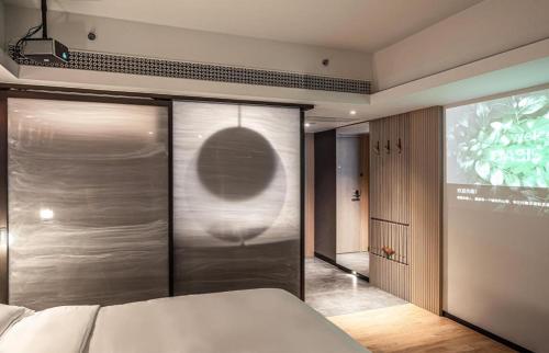 a bedroom with a bed and a sliding glass door at OASIS AVENUE-A GDH HOTEL in Hong Kong