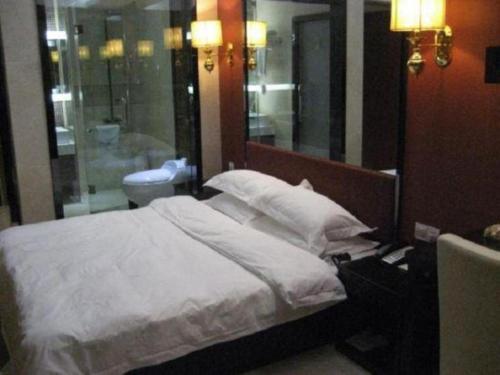 a bedroom with a bed with white sheets and pillows at Milu Hotel in Guangzhou