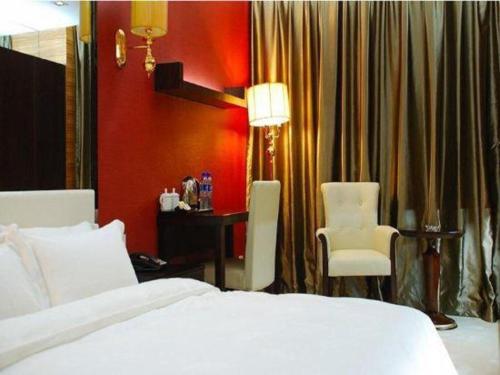 a hotel room with a bed and a desk and chair at Milu Hotel in Guangzhou