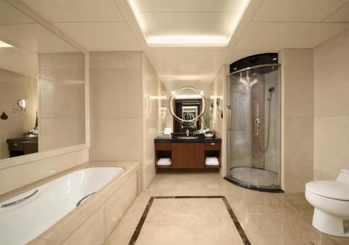 a bathroom with a tub and a toilet and a sink at Hongfeng Hotel Nanshan Branch in Shenzhen