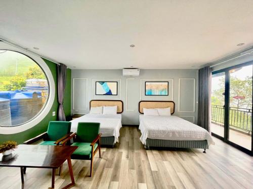 a bedroom with two beds and a table and chairs at Sunset Homestay Villa Tam Đảo in Tam Ðảo