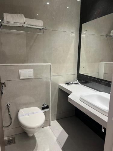 a bathroom with a toilet and a sink and a mirror at Rathna Residency in Tiruppattūr