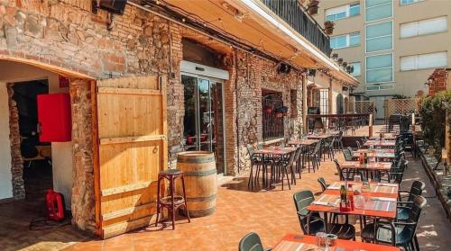 an outdoor patio with tables and chairs and a building at Hotel H in Granollers