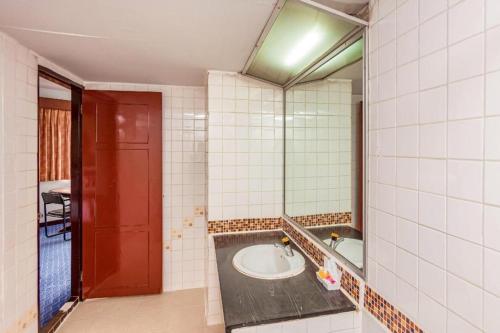 ein Badezimmer mit Waschbecken und Spiegel in der Unterkunft OYO 441 Grand Thara Hotel in Surat Thani