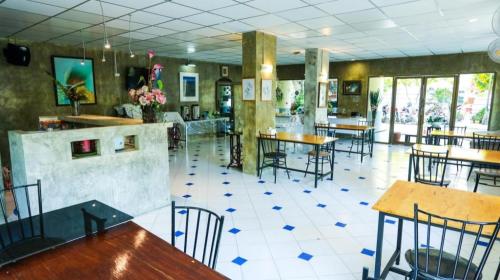 ein Restaurant mit Tischen und Stühlen in einem Raum in der Unterkunft Central Place Hotel in Ban Thai Wat Khot