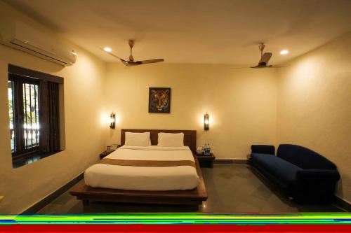 a bedroom with a bed and a futon and a pool at Adamo The Village in Matheran