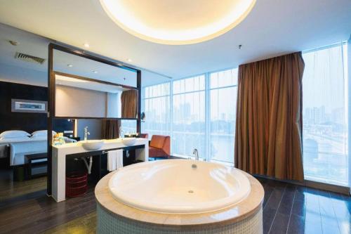 a large bathroom with a large tub in a room at Guangdong Nanmei Osotto Hotel in Guangzhou