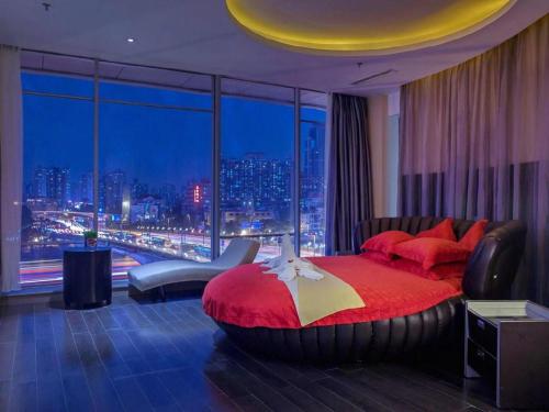 a bedroom with a red bed and a large window at Guangdong Nanmei Osotto Hotel in Guangzhou