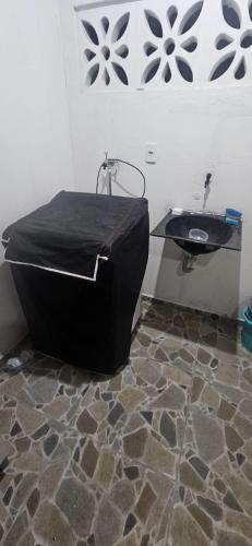 a bathroom with a black tub and a sink at aconchegante e tranquila in Parnamirim