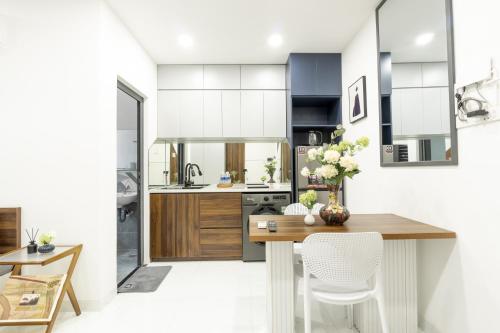 a kitchen with white cabinets and a wooden table at Nhà Sài Gòn in Ho Chi Minh City