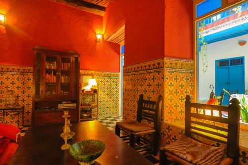 a dining room with red walls and a table and chairs at Les Matins Bleus in Essaouira