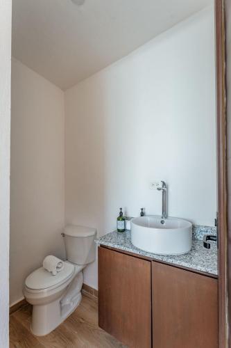 a bathroom with a toilet and a sink at Penthouse en Chicxulub in Chicxulub
