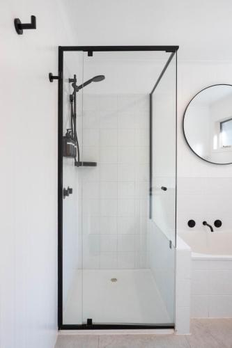 a shower with a glass door next to a sink at La Boheme Tootgarook in Tootgarook