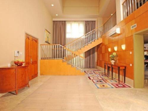 a hallway with a staircase with a table and a desk at Ocean Spring Metropark Hotel Zhuhai in Zhuhai