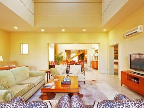 a living room with a couch and a tv at Ocean Spring Metropark Hotel Zhuhai in Zhuhai