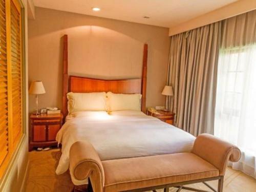 a bedroom with a large bed and a large window at Ocean Spring Metropark Hotel Zhuhai in Zhuhai