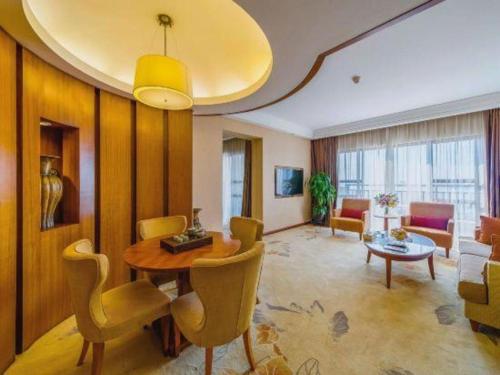 a large living room with a table and chairs at Ocean Spring Metropark Hotel Zhuhai in Zhuhai