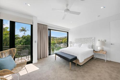 Un dormitorio blanco con una cama y una ventana grande. en Callula Noosa, en Noosa Heads