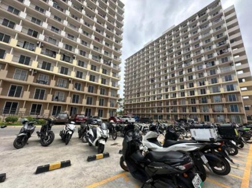 a group of motorcycles parked in front of two tall buildings at The Purrfect Stay in Lapu Lapu City