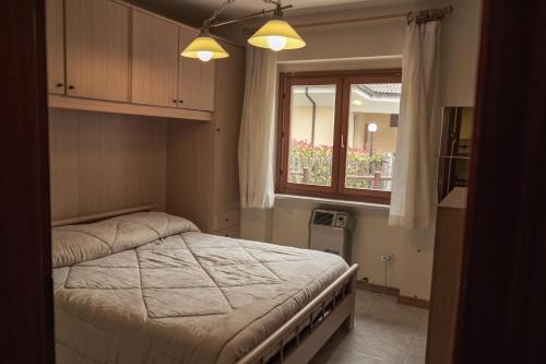 a bedroom with a large bed and a window at La casa nel bosco in Campo di Giove