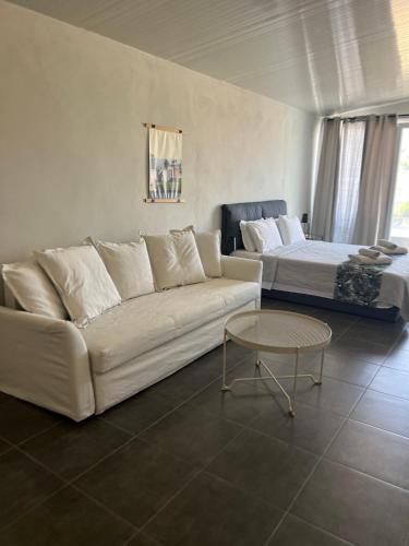 a living room with a couch and a bed at Egee Guest House in Néa Péramos