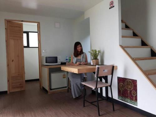 a woman sitting at a desk in a room at Khao Yai the kids adventure in Mu Si
