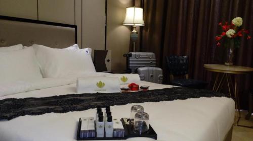 a hotel room with a large white bed with a table at Lotus Blu Hotel in Legazpi