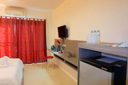 a room with a bed and a red curtain at The Pride in Nakhon Pathom