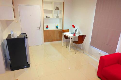 a living room with a desk and a red chair at The Pride in Nakhon Pathom