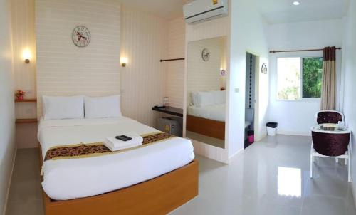 The Aam resort في بانغ ساري: غرفة فندق بها سريران وطاولة