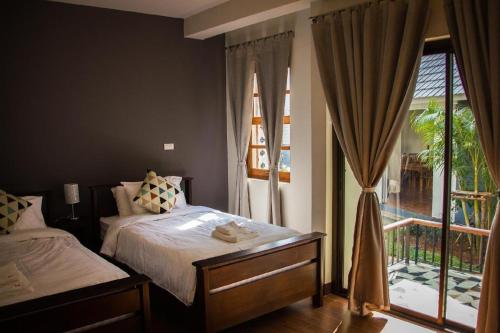 a bedroom with a bed and a large window at Phumin Place Hotel in Nan