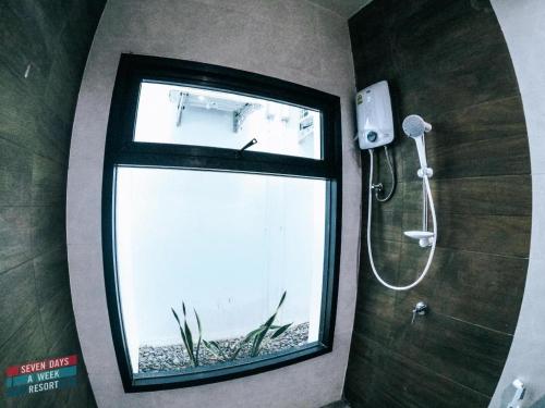 a bathroom with a shower with a window at Seven Days a Week Resort in Trang