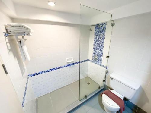 ein Badezimmer mit Toilette und Glasdusche in der Unterkunft Blue Wave Hotel Hua Hin in Hua Hin