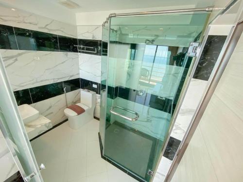 a bathroom with a glass shower and a toilet at Blue Wave Hotel Hua Hin in Hua Hin