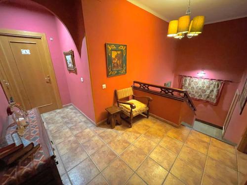 a hallway with a chair in a room with orange walls at Casa rural de la Abuela in Cadreita