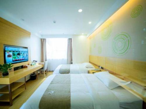 Una cama o camas en una habitación de GreenTree Inn Zhangjiagang Yangshe Old Street Stadium