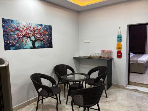 a room with chairs and a table and a painting at Spiritual Homestay in Varanasi