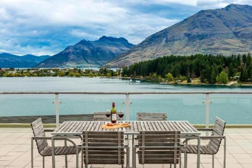 a table with a bottle of wine on top of a balcony at Oaks Queenstown Club Suites in Queenstown