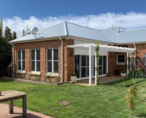 a brick house with a metal roof at 'Barton House' - Ideal Location Stroll to CBD in Orange