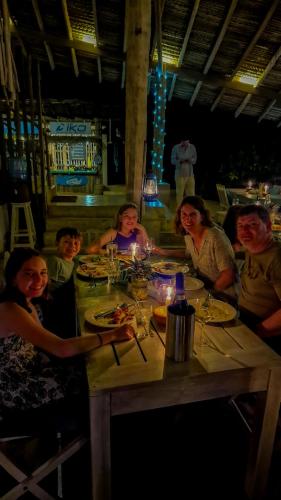 a group of people sitting at a table eating food at Elements Beach & Nature Resort in Kalpitiya
