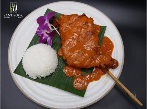 a plate of food with rice and chicken on a banana leaf at Santisookmidtown Pattani in Kampong Rusamileh